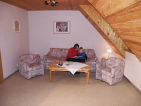 Wohnzimmer mit Sitzmöglichkeiten für bis zu 4 Erwachsene und Kinder